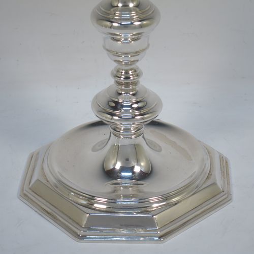 A very elegant set of four cast Sterling Silver candlesticks in a George I style, having plain round baluster bodies, and sitting on plain octagonal bases. Made by Goldsmiths and Silversmiths of Sheffield in 1931. The dimensions of this fine set of hand-made silver table candlesticks are height 19 cms (7.5 inches), the bases are 12.5 cms (5 inches) square, and the total weight is 1,602g (52 troy ounces)  