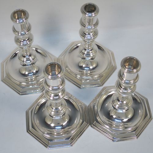 A very elegant set of four cast Sterling Silver candlesticks in a George I style, having plain round baluster bodies, and sitting on plain octagonal bases. Made by Goldsmiths and Silversmiths of Sheffield in 1931. The dimensions of this fine set of hand-made silver table candlesticks are height 19 cms (7.5 inches), the bases are 12.5 cms (5 inches) square, and the total weight is 1,602g (52 troy ounces)  