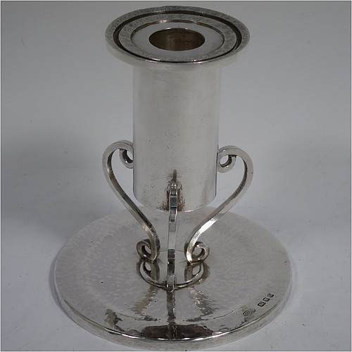 A Sterling Silver pair of modernistic style candlesticks, having round bodies with straight sides, attached to round flat hand-hammered bases with three scroll feet. Made by John Crawford Adams of London in 1981. The dimensions of these fine hand-made silver candlesticks are height 12 cms (4.75 inches), diameter at base 11 cms (4.3 inches), with a total weight of approx. 578g (18.6 troy ounces). Please note that these candlesticks are not loaded. 