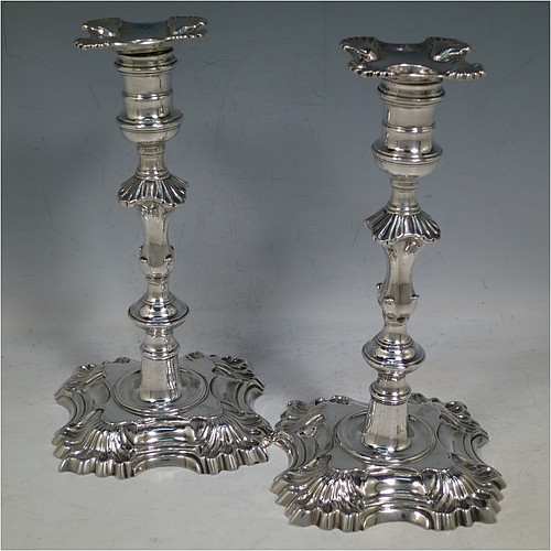 An Antique Georgian cast Sterling Silver pair of George II candlesticks, having baluster bodies, with four-shell bases, and removable nozzles. Made by Dorothy Sarbett of London in 1754. The dimensions of this fine pair of hand-made antique silver candlesticks are height 20 cms (8 inches), width at base 11 cms (4.25 inches), and they weigh a total of 965g (31 troy ounces). Please note that these items are part-crested. 