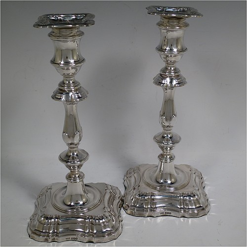 A handsome Sterling Silver pair of candlesticks in the George II four-shell corner style, having baluster bodies, with shaped square bases and shell corners, fluted baluster columns, and removable nozzles. Made by F & F of Sheffield in 1927. The dimensions of these fine hand-made silver candlesticks are height 24 cms (9.5 inches), and base 11 cms (4.25 inches) square.   