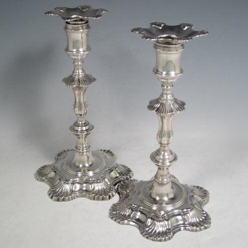 Antique Georgian cast sterling silver pair of George II candlesticks, having baluster bodies, with six-shell bases, and removable nozzles. Made by John Cafe of London in 1751/52. The dimensions of this fine pair of hand-made silver candlesticks are height 21.5 cms (8.5 inches), width at base 13 cms (5.25 inches), and they weigh a total of 1,054g (34 troy ounces).    