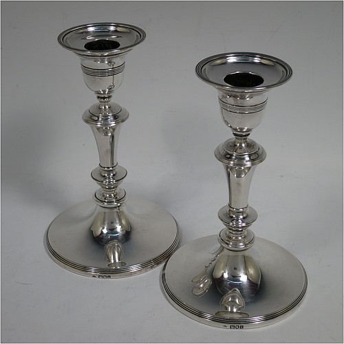 A very handsome Antique Edwardian Sterling Silver pair of candlesticks, in a very plain round style, having baluster bodies with hand-chased reeded borders, and original removable nozzles. Made by William Comyns of London in 1904. The dimensions of these fine hand-made antique silver candlesticks are height 15 cms (6 inches), and the bases are 10 cms (4 inches) in diameter.    