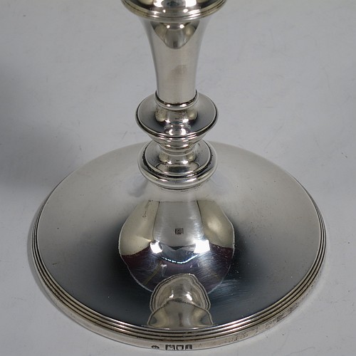 A very handsome Antique Edwardian Sterling Silver pair of candlesticks, in a very plain round style, having baluster bodies with hand-chased reeded borders, and original removable nozzles. Made by William Comyns of London in 1904. The dimensions of these fine hand-made antique silver candlesticks are height 15 cms (6 inches), and the bases are 10 cms (4 inches) in diameter.    