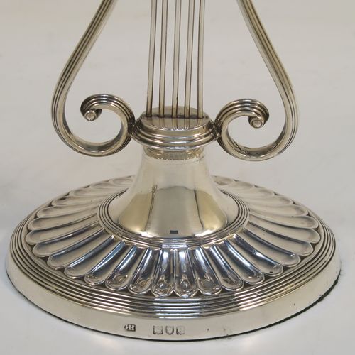 An unusual and pretty Antique Victorian Sterling Silver pair of candlesticks, having Lyre harp musical instrument style bodies, with fluted and reeded decoration, removable nozzles, and sitting on oval bases. This beautiful pair of Lyre Harp candlesticks were made by George Hancock of London in 1901. The dimensions of these fine hand-made pair of antique silver candlesticks are height 20.5 cms (8 inches), and width at base 11.5 cms (4.5 inches).   