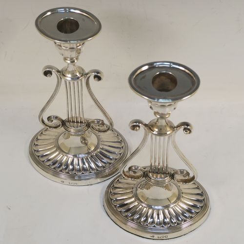 An unusual and pretty Antique Victorian Sterling Silver pair of candlesticks, having Lyre harp musical instrument style bodies, with fluted and reeded decoration, removable nozzles, and sitting on oval bases. This beautiful pair of Lyre Harp candlesticks were made by George Hancock of London in 1901. The dimensions of these fine hand-made pair of antique silver candlesticks are height 20.5 cms (8 inches), and width at base 11.5 cms (4.5 inches).   