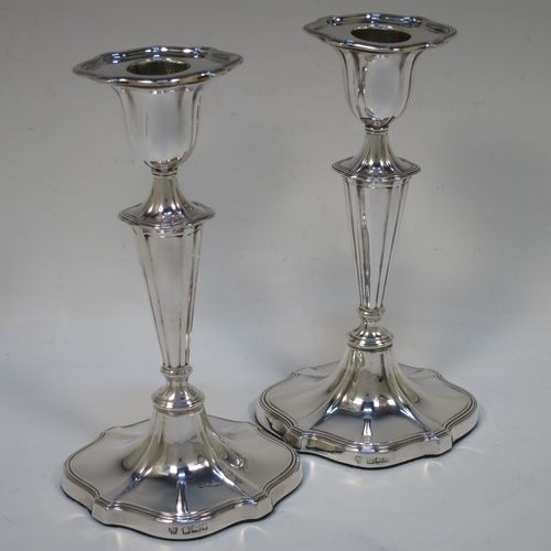 A handsome pair of Antique Edwardian Sterling Silver candlesticks, having Neoclassical style oval shaped bodies, with hand-chased fluted decoration, reeded borders, and removable nozzles. Made by Hawksworth Eyre and Co., of Sheffield in 1902. The dimensions of these fine hand-made pair of antique silver table candlesticks are height 18 cms (7 inches), length at base 10 cms (4 inches), and width at base 8 cms (3.25 inches).   