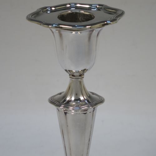 A handsome pair of Antique Edwardian Sterling Silver candlesticks, having Neoclassical style oval shaped bodies, with hand-chased fluted decoration, reeded borders, and removable nozzles. Made by Hawksworth Eyre and Co., of Sheffield in 1902. The dimensions of these fine hand-made pair of antique silver table candlesticks are height 18 cms (7 inches), length at base 10 cms (4 inches), and width at base 8 cms (3.25 inches).   