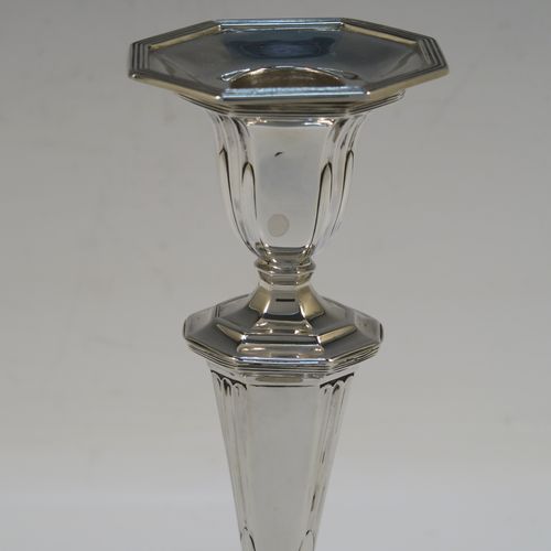 A very elegant Antique Victorian Sterling Silver pair of candlesticks, having octagonal bodies with hand-chased fluted decoration, reed-edged borders, and removable nozzles. These handsome antique silver candlesticks were made by Martin & Hall of Sheffield in 1901. The dimensions of these fine hand-made antique silver candlesticks are height 18.5 cms (7.25 inches), and the bases are 10 cms (4 inches) long, by 8 cms (3 inches) wide.   