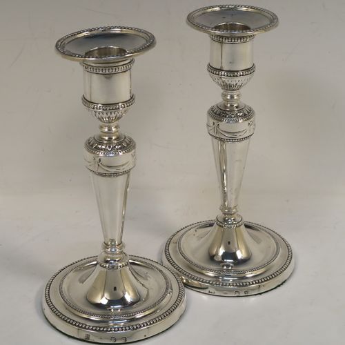 A very pretty pair of Antique Georgian Sterling Silver candlesticks in a neoclassical style, having tapering columns and round bases, with removable original nozzles, hand-chased neoclassical swag style decoration and bead-edged borders. These beautiful antique silver candlesticks were made by Daniel Smith and Robert Sharp of Sheffield in 1782/3. The dimensions of these fine hand-made antique silver candlesticks are height 16.5 cms (6.5 inches), and the bases are 9 cms (3.5 inches) diameter.   