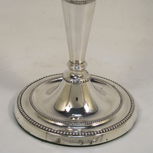 A very pretty pair of Antique Georgian Sterling Silver candlesticks in a neoclassical style, having tapering columns and round bases, with removable original nozzles, hand-chased neoclassical swag style decoration and bead-edged borders. These beautiful antique silver candlesticks were made by Daniel Smith and Robert Sharp of Sheffield in 1782/3. The dimensions of these fine hand-made antique silver candlesticks are height 16.5 cms (6.5 inches), and the bases are 9 cms (3.5 inches) diameter.   