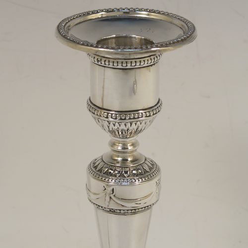 A very pretty pair of Antique Georgian Sterling Silver candlesticks in a neoclassical style, having tapering columns and round bases, with removable original nozzles, hand-chased neoclassical swag style decoration and bead-edged borders. These beautiful antique silver candlesticks were made by Daniel Smith and Robert Sharp of Sheffield in 1782/3. The dimensions of these fine hand-made antique silver candlesticks are height 16.5 cms (6.5 inches), and the bases are 9 cms (3.5 inches) diameter.   