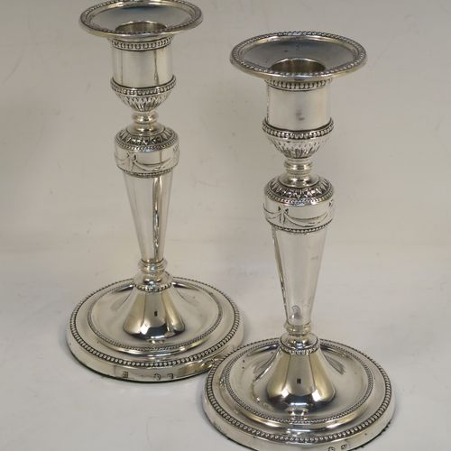 A very pretty pair of Antique Georgian Sterling Silver candlesticks in a neoclassical style, having tapering columns and round bases, with removable original nozzles, hand-chased neoclassical swag style decoration and bead-edged borders. These beautiful antique silver candlesticks were made by Daniel Smith and Robert Sharp of Sheffield in 1782/3. The dimensions of these fine hand-made antique silver candlesticks are height 16.5 cms (6.5 inches), and the bases are 9 cms (3.5 inches) diameter.   