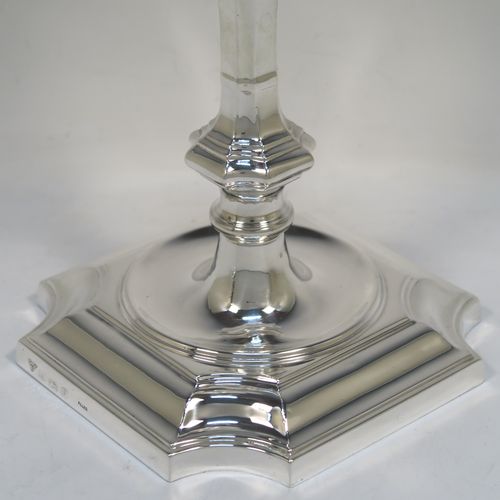 A handsome and bold pair of Sterling Silver candlesticks in a George I style, having octagonal baluster bodies, with round removable round nozzles, and sitting on cut-corner square bases. These elegant silver candlesticks were made by Garrard and Co., of Birmingham in 1984. The dimensions of these fine hand-made silver table candlesticks are height 24 cms (9.5 inches), and the bases are 14 cms (5.5 inches) square.   