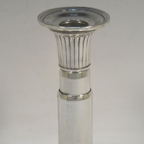 A very handsome and rare pair of Antique Georgian Sterling Silver telescopic candlesticks, having round straight-sided columns, with fluted decoration round the tops and bases, and removable nozzles. These elegant antique silver telescopic candlesticks were made by George Ashfoed and Co., of Sheffield in 1800. The dimensions of these fine hand-made antique silver telescopic candlesticks are height collapsed 18 cms (5 inches), extended 27 cms (10.5 inches), and the diameter of the bases are 11.5 cms (4.5 inches). Please note that these items are part crested. 