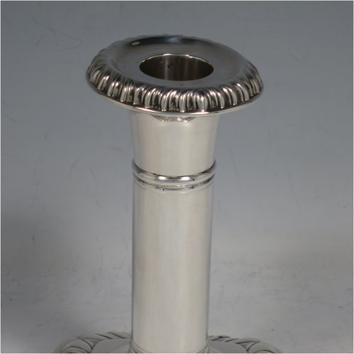 An Antique Victorian Sterling Silver pair of candlesticks, in a Georgian Regency style with plain round columns on square bases with rounded corners, gadroon edged borders, and removable nozzles. Made by Matthew John Jessop of London in 1895. The dimensions of this fine pair of hand-made silver candlesticks are height 14 cms (5.5 inches), and the bases are 9 cms (3.5 inches) square.