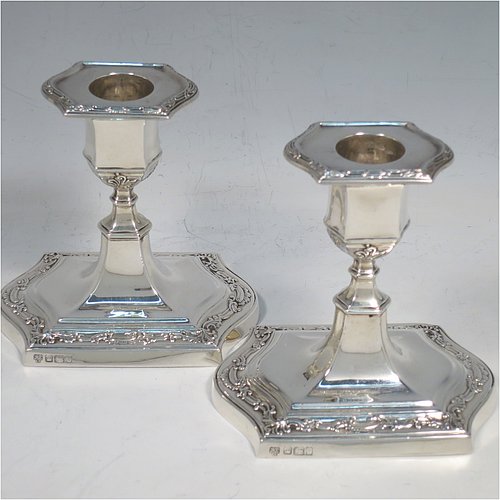 An Antique Edwardian Sterling Silver very pretty pair of small candlesticks, having shaped rectangular bodies, with hand-chased floral borders, and removable nozzles. Made by Hawksworth & Eyre ltd., of Sheffield in 1902. The dimensions of these fine hand-made antique silver candlesticks are height 10 cms (4 inches), and the bases are 10 cms (4 inches) long, by 7.5 cms (3 inches) wide.   