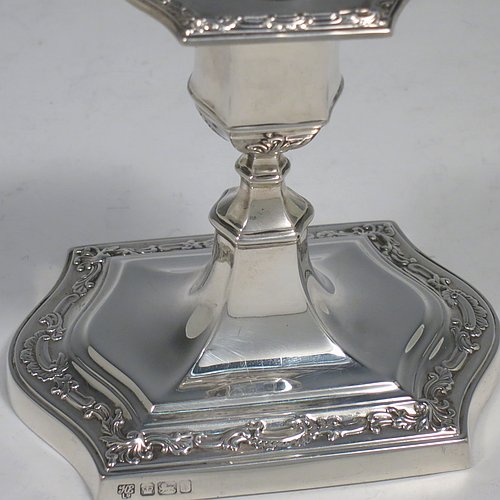 An Antique Edwardian Sterling Silver very pretty pair of small candlesticks, having shaped rectangular bodies, with hand-chased floral borders, and removable nozzles. Made by Hawksworth & Eyre ltd., of Sheffield in 1902. The dimensions of these fine hand-made antique silver candlesticks are height 10 cms (4 inches), and the bases are 10 cms (4 inches) long, by 7.5 cms (3 inches) wide.   