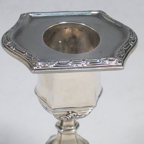 An Antique Edwardian Sterling Silver very pretty pair of small candlesticks, having shaped rectangular bodies, with hand-chased floral borders, and removable nozzles. Made by Hawksworth & Eyre ltd., of Sheffield in 1902. The dimensions of these fine hand-made antique silver candlesticks are height 10 cms (4 inches), and the bases are 10 cms (4 inches) long, by 7.5 cms (3 inches) wide.   