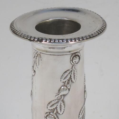 A very pretty Antique Edwardian Sterling Silver pair of candlesticks, in a Corinthian style with hand-chased floral and leaf decoration on the columns and bead-edged borders, removable nozzles, and square stepped bases. Made by Hawksworth, Eyre and Co., of Sheffield in 1909. The dimensions of this fine pair of hand-made antique silver candlesticks are height 13 cms (5 inches), and the bases are 8 cms (3.25 inches) square.  