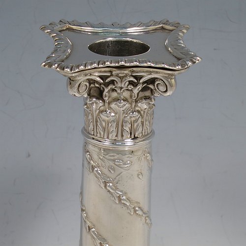 An Antique Victorian Sterling Silver pair of candlesticks, in the Corinthian style with gadroon-edged borders, removable nozzles, having columns with hand-chased garlands of flowers, and square stepped bases. Made by J. K. Bembridge of Sheffield in 1891. The dimensions of this fine pair of hand-made antique silver candlesticks are height 16 cms (6.25 inches), and the bases are 8.5 cms (3.3 inches) square.    