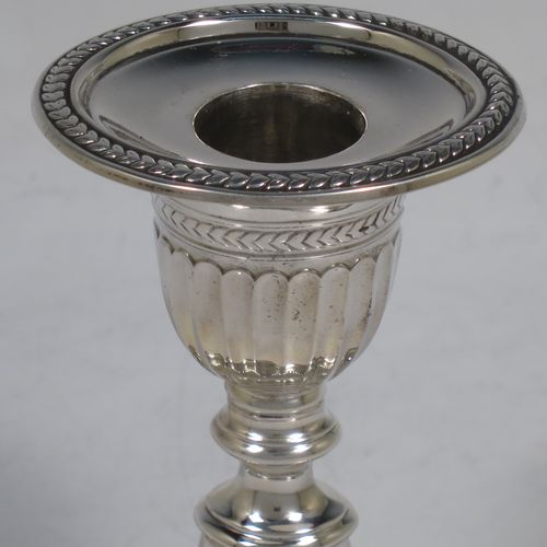 A very pretty pair of Antique Edwardian Sterling Silver candlesticks, having oval bodies with hand-chased half-fluted decoration, original removable nozzles with applied leaf-style borders. Made by Fordham and Faulkner of Sheffield in 1906. The dimensions of these fine hand-made antique silver candlesticks are height 11 cms (4.25 inches), and the bases are 11 cms (4.25 inches) long.    