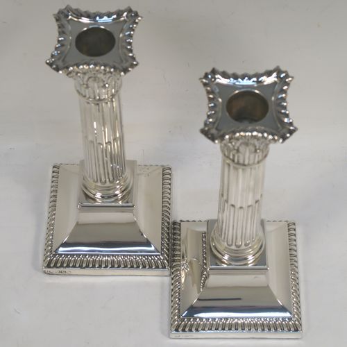 A very handsome and bold pair of Sterling Silver of Corinthian style candlesticks, having traditional gadroon borders, acanthus-leaf capitals, fluted columns, removable nozzles, and square stepped bases. These beautiful silver candlesticks were made by Hawksworth Eyre and Co., of Sheffield in 1923. The dimensions of this fine hand-made pair of silver candlesticks are height 19.5 cms (7.75 inches), and the bases are 8.5 cms (3.3 inches) square.   