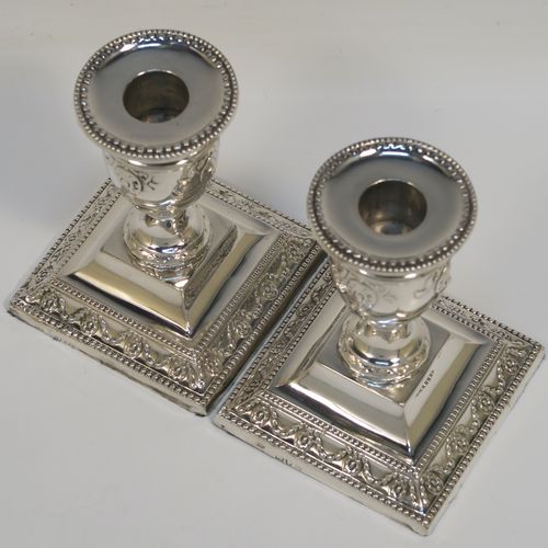 A very pretty pair of Antique Victorian Sterling Silver candlesticks, having urn-shaped bodies sitting on square pedestal bases, with hand-chased neoclassical style decoration, bead-edged borders, and removable nozzles. These beautiful antique silver candlesticks were made by Charles Boyton of London in 1892. The dimensions of these fine hand-made silver candlesticks are height 11 cms (4.3 inches), and the bases are 8.5 cms (3.3 inches) square.

  