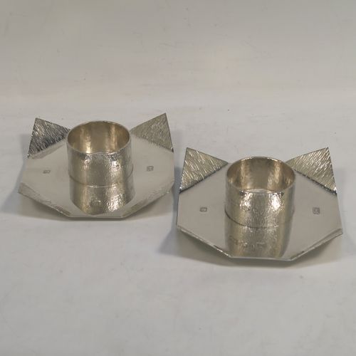 A very unusual Sterling Silver pair of modernistic style candlesticks, having square bodies with folded corners, central candle holders, and decorated with a bark-like finish, and all sitting on simple round collet feet. These very individual silver candlestick holders were made by SP of London in 2001. The dimensions of these fine hand-made silver candlesticks are height 3 cms (1.25 inches), 10 cms (4 inches) square, with a total weight of approx. 295g (9.5 troy ounces). Please note that these candlesticks are not loaded.   