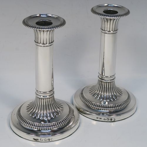 A very handsome pair of Antique Georgian Sterling Silver candlesticks, having round bases with plain straight columns, with hand-chased fluted decoration and gadroon borders to the removable nozzles. These elegant antique silver candlesticks were made by John Roberts of Sheffield in 1808. The dimensions of these fine hand-made antique Georgian silver candlesticks are height 17 cms (6.75 inches), and the bases are 11 cms (4.3 inches) in diameter.   