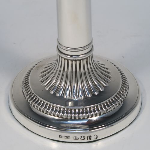 A very handsome pair of Antique Georgian Sterling Silver candlesticks, having round bases with plain straight columns, with hand-chased fluted decoration and gadroon borders to the removable nozzles. These elegant antique silver candlesticks were made by John Roberts of Sheffield in 1808. The dimensions of these fine hand-made antique Georgian silver candlesticks are height 17 cms (6.75 inches), and the bases are 11 cms (4.3 inches) in diameter.   