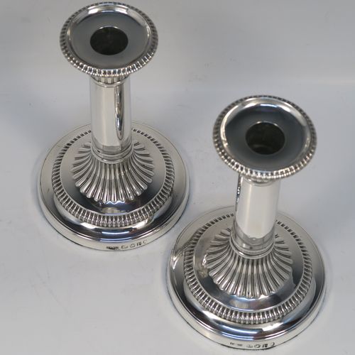 A very handsome pair of Antique Georgian Sterling Silver candlesticks, having round bases with plain straight columns, with hand-chased fluted decoration and gadroon borders to the removable nozzles. These elegant antique silver candlesticks were made by John Roberts of Sheffield in 1808. The dimensions of these fine hand-made antique Georgian silver candlesticks are height 17 cms (6.75 inches), and the bases are 11 cms (4.3 inches) in diameter.   