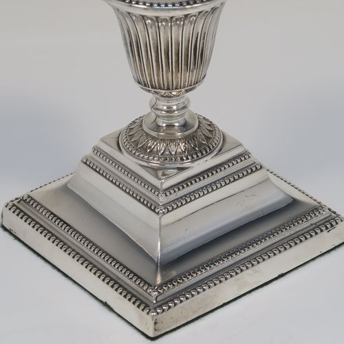 A small but very pretty pair of Antique Victorian Sterling Silver candlesticks, having urn-shaped bodies with fluted and anthemion leaf decoration, with applied bead-edged borders, sitting on square bases, and original removable nozzles. These beautiful silver candlesticks were made by Richard Hodd and Sons of London in 1877. The dimensions of these fine hand-made antique silver candlesticks are height 9 cms (3.5 inches), and the bases are 7.5 cms (3 inches) square.   