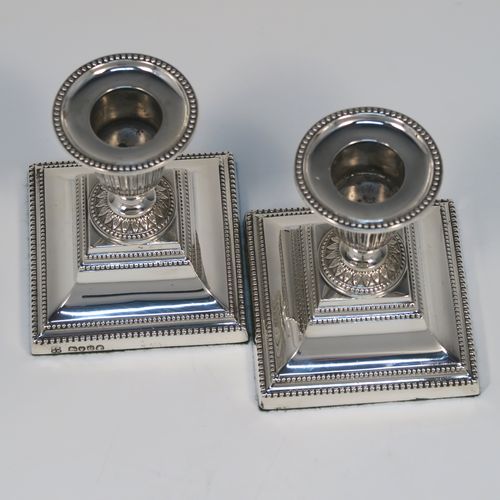 A small but very pretty pair of Antique Victorian Sterling Silver candlesticks, having urn-shaped bodies with fluted and anthemion leaf decoration, with applied bead-edged borders, sitting on square bases, and original removable nozzles. These beautiful silver candlesticks were made by Richard Hodd and Sons of London in 1877. The dimensions of these fine hand-made antique silver candlesticks are height 9 cms (3.5 inches), and the bases are 7.5 cms (3 inches) square.   