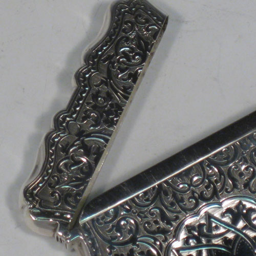 Antique Victorian sterling silver calling card case, having a shaped rectangular body with hand-engraved floral and geometrical decoration, and a side-hinged lid. Made by C. H. Cheshire of  Birmingham in 1876. The dimensions of this fine hand-made silver card case are length 10 cms (4 inches), width 7 cms (2.75 inches), and it weighs approx. 78g (2.5 troy ounces).   