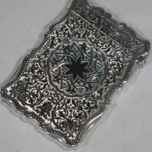 Antique Victorian sterling silver calling card case, having a shaped rectangular body with hand-engraved floral and geometrical decoration, and a side-hinged lid. Made by C. H. Cheshire of  Birmingham in 1876. The dimensions of this fine hand-made silver card case are length 10 cms (4 inches), width 7 cms (2.75 inches), and it weighs approx. 78g (2.5 troy ounces).   