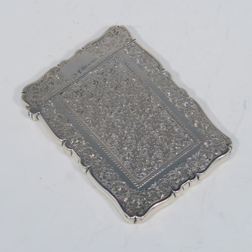 A very pretty Antique Victorian Sterling Silver calling card case, having a shaped rectangular body with pristine hand-engraved floral and Ivy decoration, and a side-hinged lid. This beautiful silver card case was made by Alfred Hall and John Goode of London in 1883. The dimensions of this fine hand-made antique silver card case are length 10 cms (4 inches), width 7 cms (2.75 inches), and it weighs approx. 64g (2 troy ounces).   