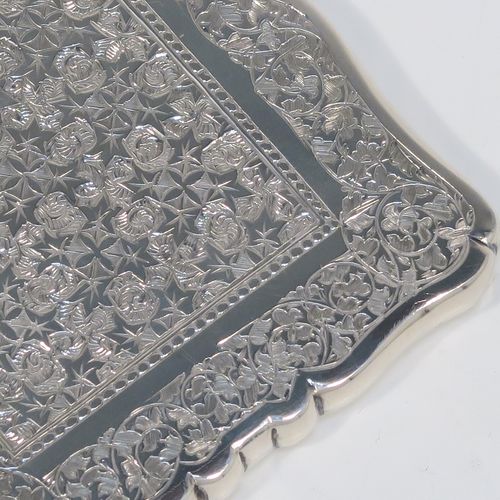 A very pretty Antique Victorian Sterling Silver calling card case, having a shaped rectangular body with pristine hand-engraved floral and Ivy decoration, and a side-hinged lid. This beautiful silver card case was made by Alfred Hall and John Goode of London in 1883. The dimensions of this fine hand-made antique silver card case are length 10 cms (4 inches), width 7 cms (2.75 inches), and it weighs approx. 64g (2 troy ounces).   