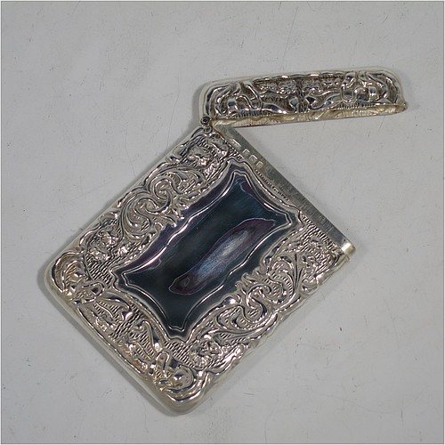 A very pretty Antique Edwardian Sterling Silver Art Nouveau card case, having a hand-chased rectangular body with floral and scroll decoration, a hanged lid, and two vacant cartouches on either side. Made by Cornelius Saunders and Frank Shepherd of Birmingham in 1905. The dimensions of this fine hand-made antique silver card case are length 9.5 cms (3.75 inches), width 7 cms (2.75 inches), and it weighs approx. 69g (2.2 troy ounces).