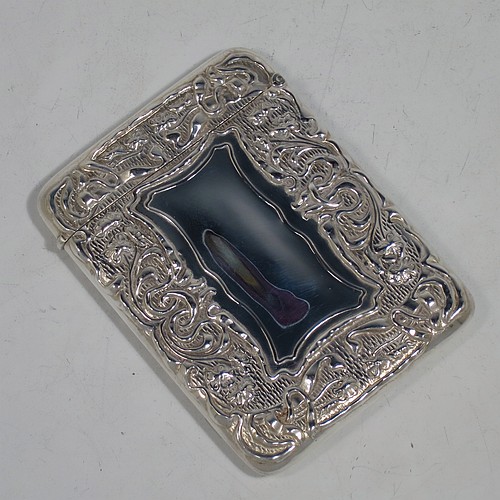 A very pretty Antique Edwardian Sterling Silver Art Nouveau card case, having a hand-chased rectangular body with floral and scroll decoration, a hanged lid, and two vacant cartouches on either side. Made by Cornelius Saunders and Frank Shepherd of Birmingham in 1905. The dimensions of this fine hand-made antique silver card case are length 9.5 cms (3.75 inches), width 7 cms (2.75 inches), and it weighs approx. 69g (2.2 troy ounces).