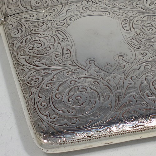 A very pretty Antique Victorian Sterling Silver calling card case, having a rectangular body with rounded shoulders, hand-engraved floral decoration, a vacant central cartouche on one side, and a side-hinged lid. Made by George Loveridge of Birmingham in 1898. The dimensions of this fine hand-made antique silver card case are length 10 cms (4 inches), width 7.5 cms (3 inches), and it weighs approx. 88g (2.8 troy ounces).   