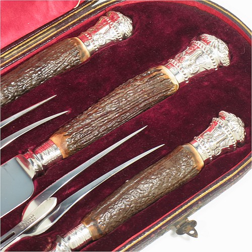 A very handsome, large, and complete Antique Victorian Sterling Silver and deer antler horn carving set, consisting of two forks with working guards, two knives, and one sharpening steel, with original bone antler handles and silver ferrules with hand-chased bead-work and rams heads, all in their original red silk and maroon velvet-lined presentation box. Made by James Round of Sheffield in 1886. The dimensions of this fine hand-made antique silver and bone handled carving set are length of longest knife 43 cms (17 inches), and length of shortest fork 28 cms (11 inches)   