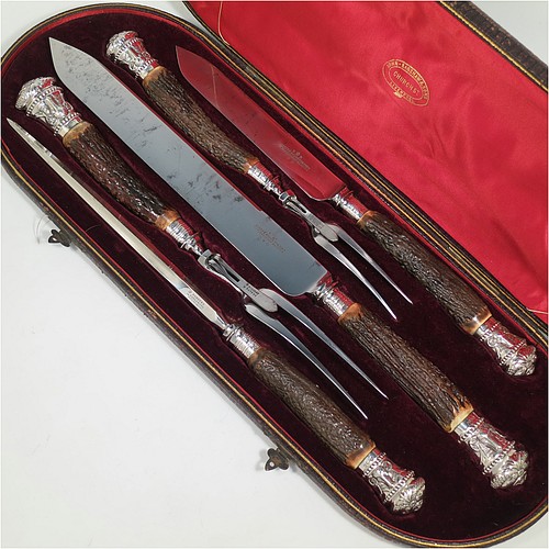 A very handsome, large, and complete Antique Victorian Sterling Silver and deer antler horn carving set, consisting of two forks with working guards, two knives, and one sharpening steel, with original bone antler handles and silver ferrules with hand-chased bead-work and rams heads, all in their original red silk and maroon velvet-lined presentation box. Made by James Round of Sheffield in 1886. The dimensions of this fine hand-made antique silver and bone handled carving set are length of longest knife 43 cms (17 inches), and length of shortest fork 28 cms (11 inches)   