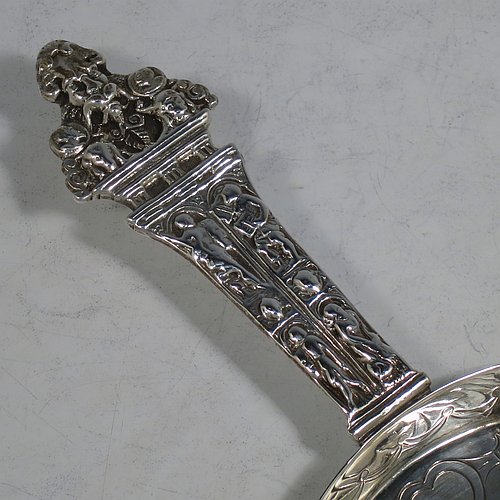 An Antique Victorian Sterling Silver Arts and Crafts style chamberstick, having a round hand-chased main body with raised border, with a central candle-holder and removable nozzle, and a cast medieval style figural handle. This beautiful copy of a 17th century style chamberstick was made by William Summers of London in 1877. The dimensions of this fine hand-made antique silver chamber-stick are length 24 cms (9.5 inches), diameter 12 cms (4.75 inches), and it weighs approx. 287g (9.3 troy ounces).