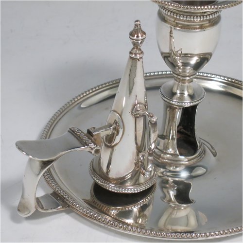 An Antique Georgian Sterling Silver chamber-stick, having a round base, a handle with thumb-piece, an original removable dunce-cap extinguisher, an original removable nozzle, and with applied bead-edged borders. Made by John Crouch & Thomas Hannam of London in 1782. The dimensions of this fine hand-made silver chamberstick are diameter 13.5 cms (5.3 inches), height 10 cms (4 inches), and it weighs approx. 245g (7.9 troy ounces).   