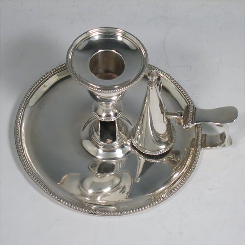 An Antique Georgian Sterling Silver chamber-stick, having a round base, a handle with thumb-piece, an original removable dunce-cap extinguisher, an original removable nozzle, and with applied bead-edged borders. Made by John Crouch & Thomas Hannam of London in 1782. The dimensions of this fine hand-made silver chamberstick are diameter 13.5 cms (5.3 inches), height 10 cms (4 inches), and it weighs approx. 245g (7.9 troy ounces).   