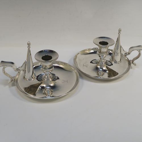 A very handsome pair of Antique Victorian Sterling Silver chambersticks, having very plain round bodies, with original removable nozzles and dunce-cap snuffers. These elegant silver chambersticks were made by Robert Garrard (the Royal Goldsmith of the time) of London in 1866. The dimensions of these fine hand-made antique silver chamber-sticks are height 10 cms (4 inches), diameter 15 cms (6 inches), and they weigh a total of approx. 812g (26 troy ounces). Please note that these items are part-crested.