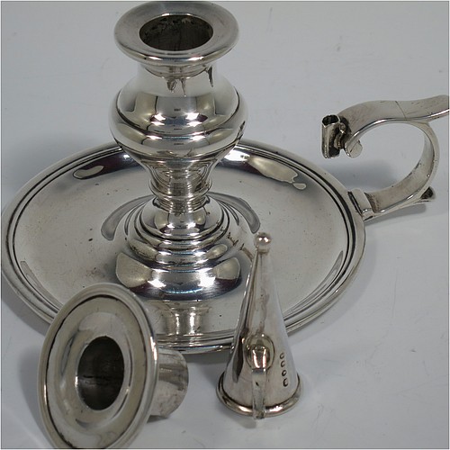 An Antique Victorian Sterling Silver small chamber-stick, having a plain body with a round base, a cast plain scroll handle, an original removable dunce-cap extinguisher, an original removable nozzle, and with applied reed-edged borders. Made by Samuel Hayne and Dudley Cater of London in 1850. The dimensions of this fine hand-made antique silver chamberstick are diameter 10 cms (4 inches), height 7 cms (2.75 inches), and it weighs approx. 179g (5.8 troy ounces).    