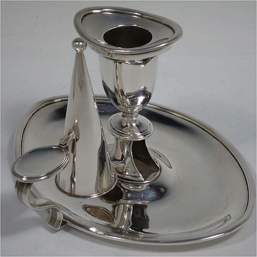 A very handsome pair of Antique Georgian Sterling Silver chamber-sticks, having plain oval bodies, scroll handles with thumb-pieces, original removable dunce-cap extinguishers, original removable nozzles, and with applied reed-edged borders. Made by James Ellis and Co., of Sheffield in 1795. The dimensions of these fine hand-made antique silver chambersticks are length 17 cms (6.75 inches), width 13 cms (5 inches), height 10 cms (4 inches), and they weigh a total of approx. 580g (18.7 troy ounces).    