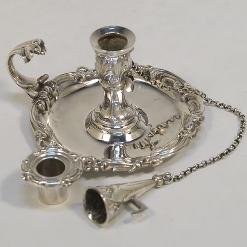 A very pretty Antique early Victorian Sterling Silver small chamber-stick for taper-stick size candles, having a round body with applied scroll and floral borders, a cast scroll handle, an original removable dunce-cap extinguisher with a security chain, and an original removable nozzle. This beautiful antique silver chamberstick was made by the Barnard Brothers of London in 1838. The dimensions of this fine hand-made silver chamberstick are diameter 9 cms (3.5 inches), height 5.5 cms (2.25 inches), and it weighs approx. 117g (3.8 troy ounces).  